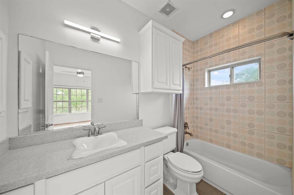 This Chic Ensuite Bath to the Second Bedroom offers a Quartz Style Topped Vanity, Kohler Designer Style White Porcelain Sink, Polished Nickel Faucet, White Painted Cabinets and Drawers, Fresh Designer Paint, and a 3 Light Polished Nickel Light Fixture.  The Bath also offers a Full Tub/Shower with Tile Surround, Rain Shower Head, and Recessed Light.