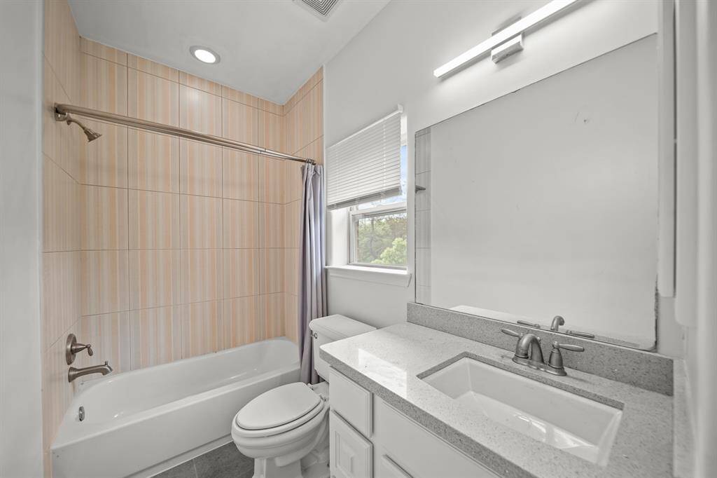 The Ensuite Bath to the Third Bedroom features a Quartz Style Topped Vanity, White Porcelain Sink, White Painted Cabinets and Drawers, and 3 Light Polished Nickel Light Fixture.  This Bath also boasts a Linen Closet, Fresh Designer Paint, Kohler Commode, Natural Stone Style Floors, and a Full Tub/Shower with Tile Surround, Rain Shower Head, and Recessed Light.