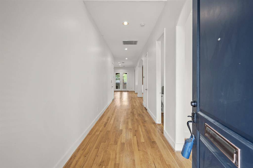The Welcoming 2 Story Foyer offers Brand New (April 2025) Refinished Natural Hardwood Floors, Fresh Designer Paint, and LED Lighting.