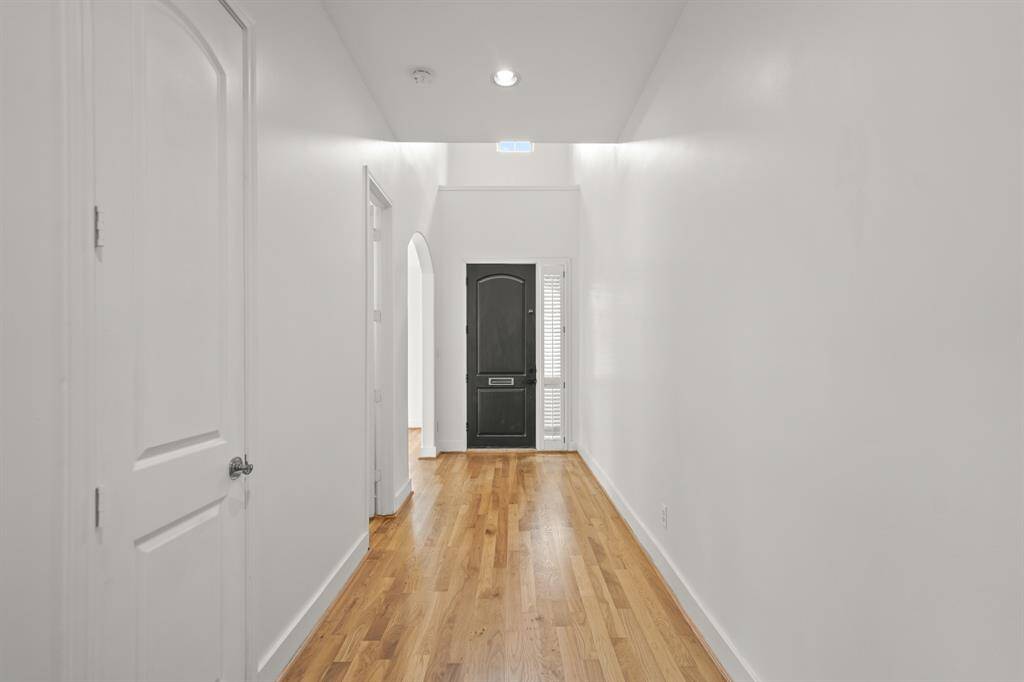 The Spacious Foyer (Approximately 19'6" x 6'1") features a Polished Chrome Contemporary Chandelier, Coat Closet, and an Arched Doorway from the Foyer to the Dining Area.