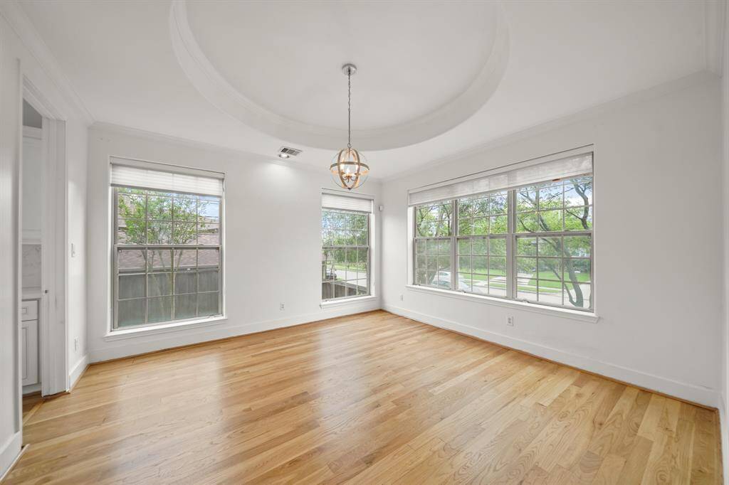 The Dining Area boasts an Architecturally Designed Ceiling, Picture Sized Windows that view the Landscaped Front Yard and the Grassy Side Yard, and Silhouette Style Pleated Shades.