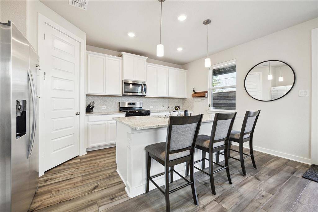 Fully equipped kitchen including energy star appliances, including refrigerator, gas oven and stove top.