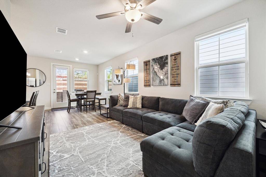 View of the living area from the staircase. Custom shades have been added to all windows. Tons of natural light! All windows are energy efficient.