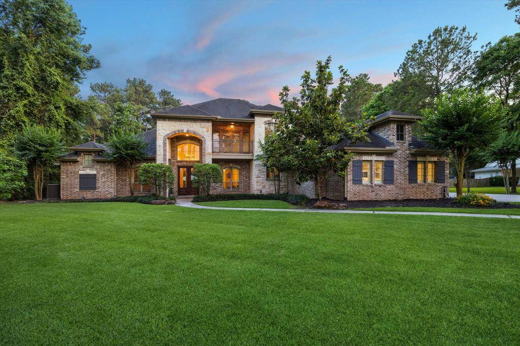 Proudly introducing 10250 Clubhouse Circle, a distinguished residence in the highly sought-after community of Lake Windcrest. This impressive brick and stone estate captivates with its grand elevation, expansive manicured lawn, and timeless architectural details. Perfectly situated on a spacious 2 acre (+/-) lot, the home is surrounded by mature trees and thoughtfully accented with uplighting, creating a welcoming ambiance and stunning curb appeal—especially at dusk.
