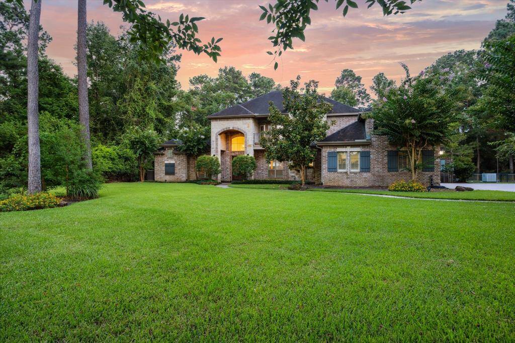 An alternate view of the front elevation highlights the home’s timeless brick and stone exterior, grand entry, and stately symmetry. The wide front lawn and established trees create a picture-perfect first impression.