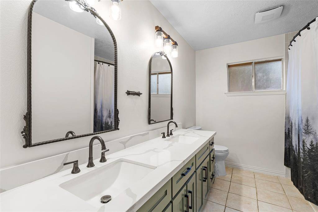 Enjoy the clean lines and fresh feel of the updated secondary bathroom with tub/shower combo, vanity with dual sinks, sleek countertops, and practical storage.