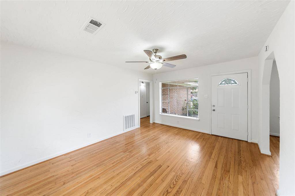Living room with an abundance of lighting and hardwood floors