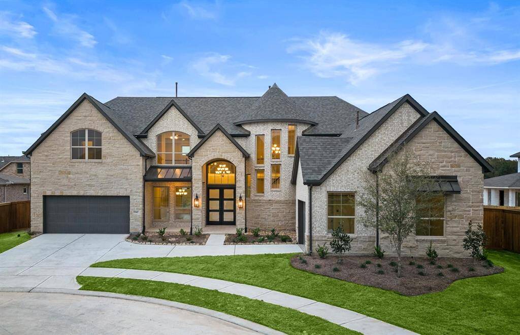 Nestled on a quiet cul-de-sac in Towne Lake, this two-story home stuns with its elegant stone façade, striking rooflines, sweeping driveway and a 3-car split garage.