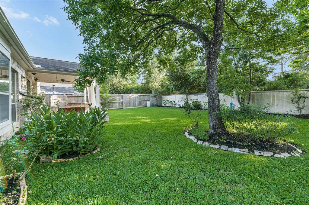 Beautiful backyard with lush landscaping and a sprinkler system.