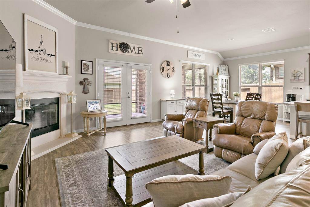 This inviting living room features a cozy fireplace and flows easily from kitchen, to dining area creating a welcoming space for relaxation and entertaining.