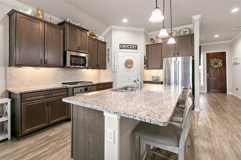 Modern kitchen with plenty of counter space and storage.  New KitchenAid refrigerator to remain.