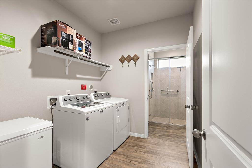 Sizable laundry room connects to primary bathroom for convenience.  Washer and dryer to remain.
