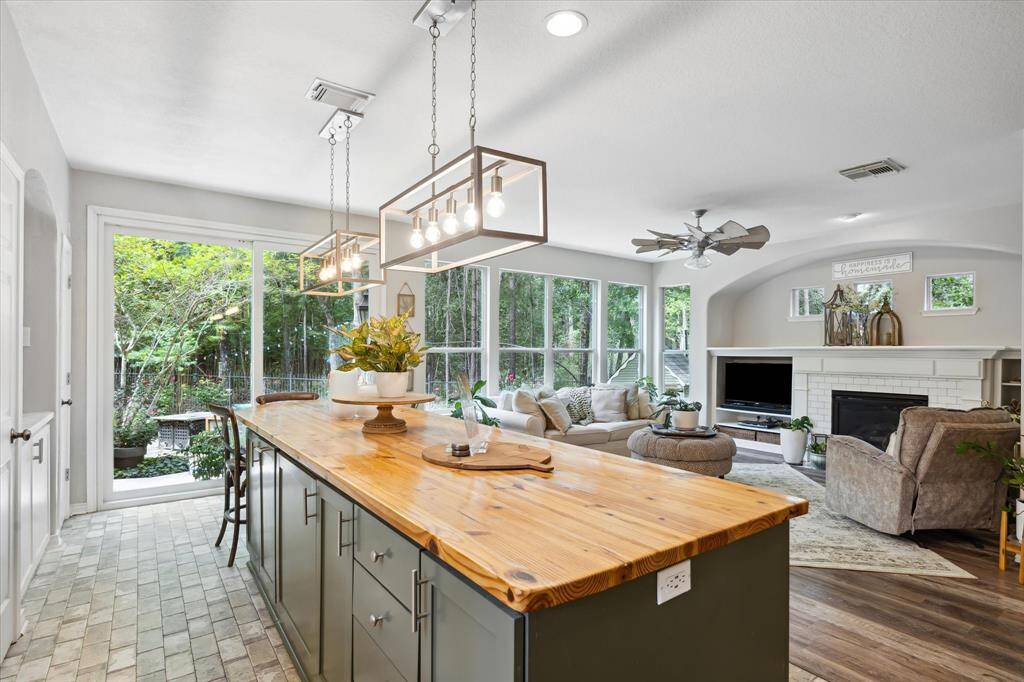 From the kitchen, enjoy a seamless view into the living room and beyond to the lush greenbelt. Walls of windows bring the outdoors in, offering tranquil wooded scenery and easy access to the backyard—perfect for relaxing or entertaining.