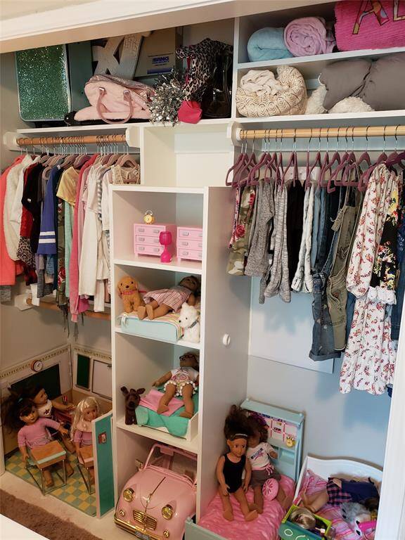 An excellent example of how to style a closet in a secondary bedroom—this thoughtfully organized space combines functionality with personality. Ample shelving and hanging space keep clothing and linens neatly arranged, while a dedicated play zone adds a whimsical touch that enhances the room’s charm. Perfect for showcasing how secondary bedrooms can be both practical and imaginative.