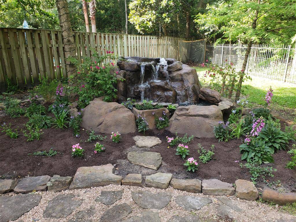 This angle offers a closer look at the freshly mulched flower beds and colorful plantings that surround the fountain, enhancing its visual appeal and integrating it beautifully into the natural landscape.