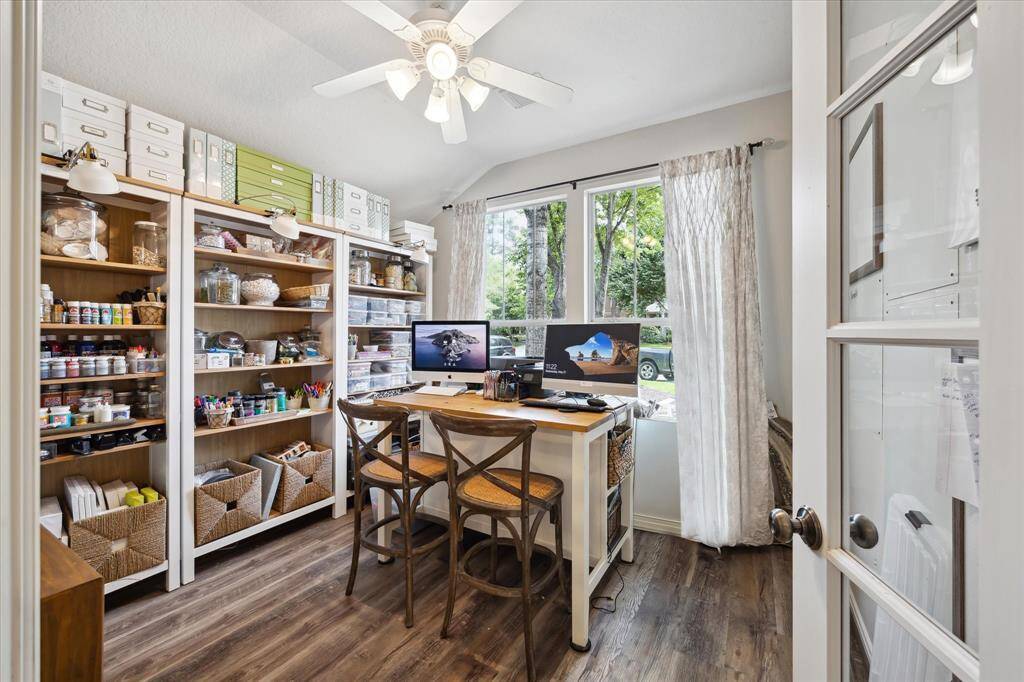Bright and functional, this versatile study—currently styled as a craft room—features rich vinyl plank flooring and large windows that bathe the space in natural light. Whether used for remote work, creative pursuits, or quiet focus, it offers a peaceful and inspiring setting.