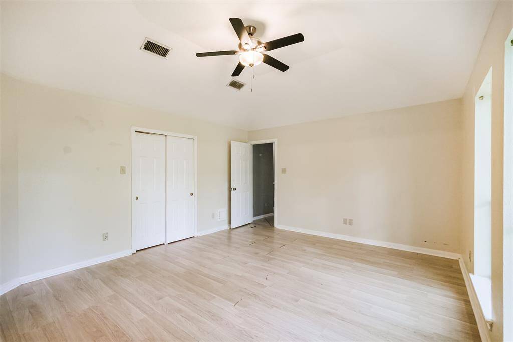 Primary bedroom features tall ceilings and a ceiling fan for comfort.