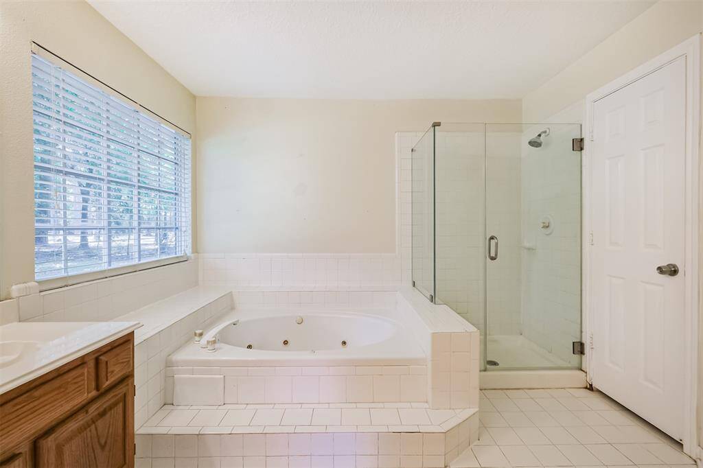 Bathroom includes a soaking jetted tub and a separate walk-in shower.