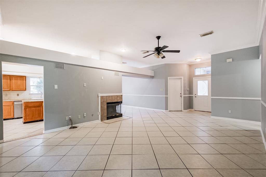 Open living room with tiled flooring and a ceiling fan for comfort.
