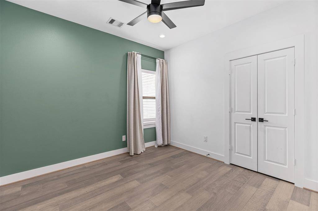 Secondary Room with Beautifully Painted Accent Wall and Double-Door Closet