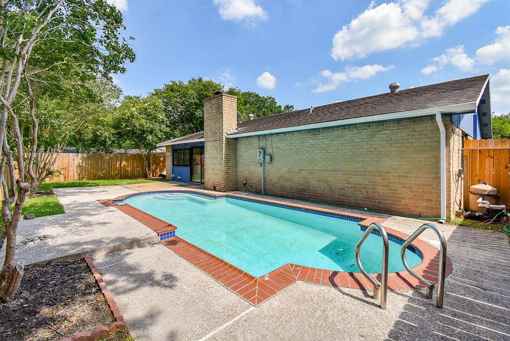 An outdoor oasis awaits—this private pool area is framed by garden beds and secure fencing. Whether you're swimming laps or lounging with a book, it’s a tranquil escape from Houston’s summer sun.