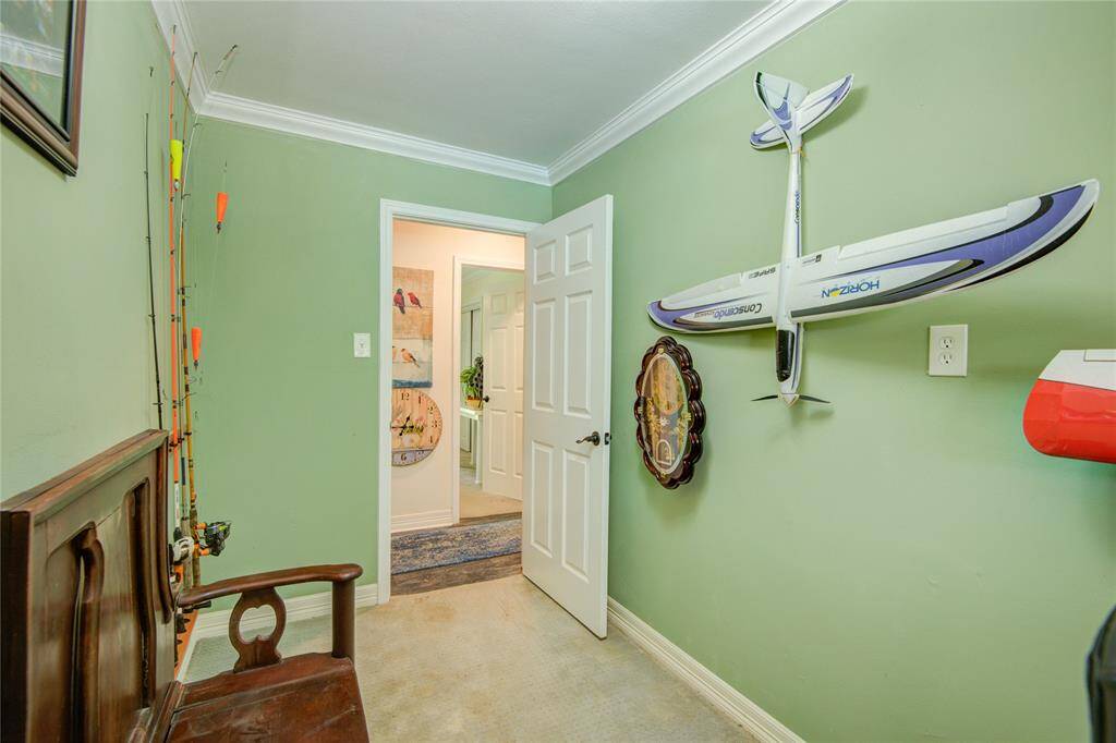 This versatile flex space features crown molding and serene backyard views, making it an ideal spot for a home office, workout area, or creative studio.