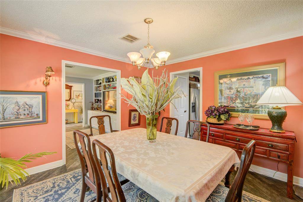 This elegant formal dining room features detailed crown molding, and a warm, neutral palette that exudes timeless charm.