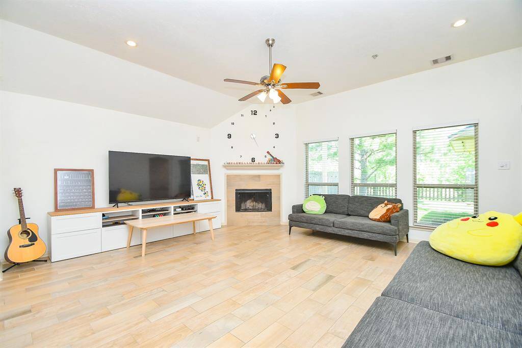 Open-concept family room with high ceilings, built-in entertainment niche, and tile flooring throughout.