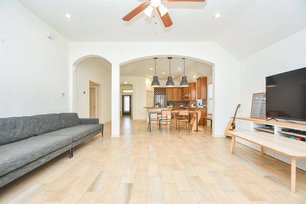 Open-concept family room with high ceilings, built-in entertainment niche, and tile flooring throughout.