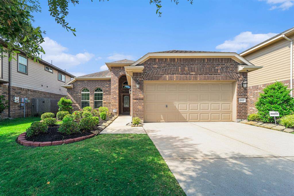 Charming brick exterior with a welcoming entryway, manicured landscaping, and a spacious two-car garage. Perfect blend of style and functionality.