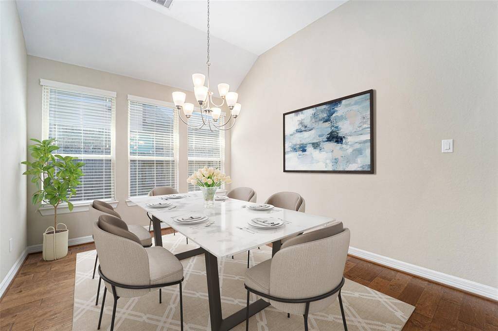 Bright and inviting dining room featuring elegant hardwood floors, high ceilings, and ample natural light from large windows. Perfect for gatherings and memorable meals.