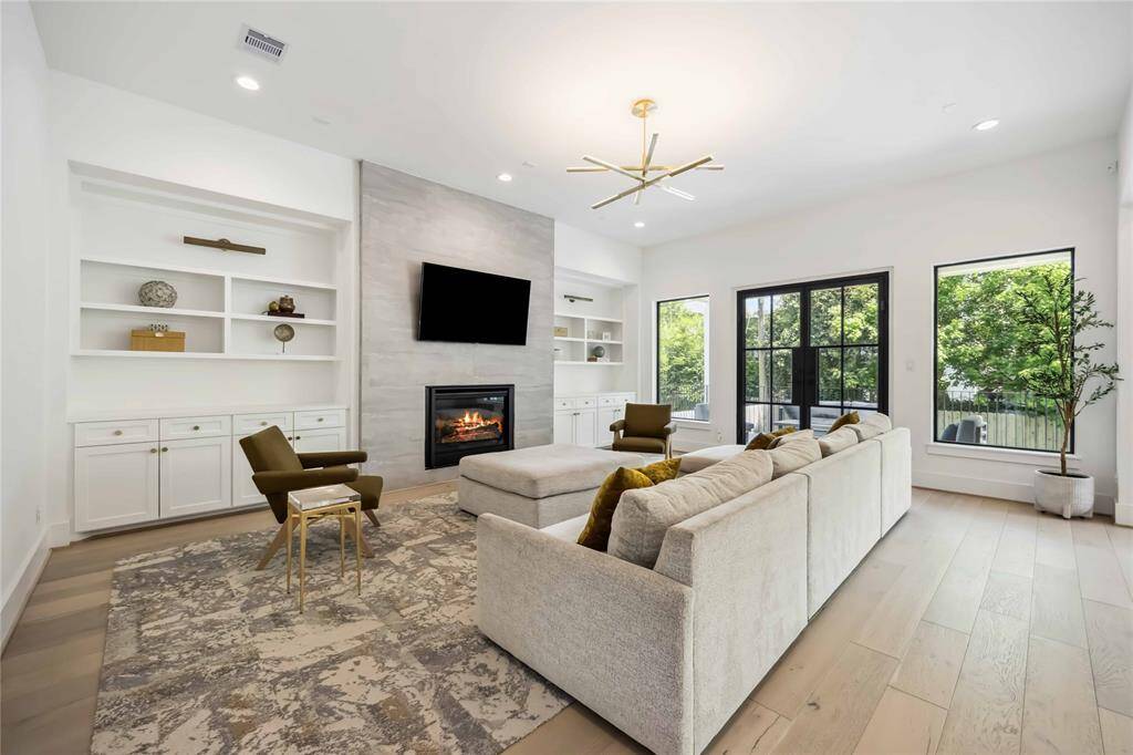 A beautifully curated kitchen and breakfast space with sleek countertops, designer lighting, and expansive windows that invite natural light and backyard views.