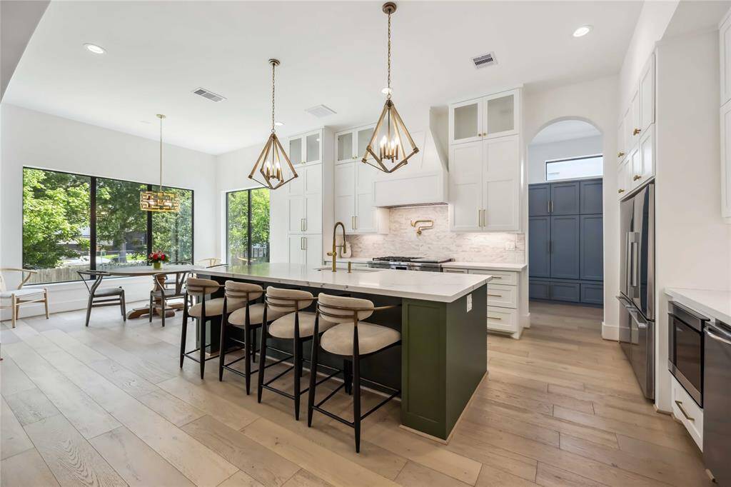 Open-concept chef’s kitchen with a beautiful view of the family room—designed for effortless entertaining while you cook, with premium appliances, a separate ice maker, and an expansive island for gathering.
