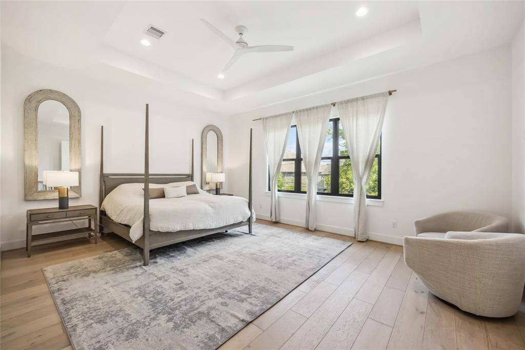 Primary bath designed with custom cabinetry, elegant hardware, and a frameless glass shower featuring a built-in bench, recessed niche, and matte black fixtures—bringing luxury and function together in one serene space.