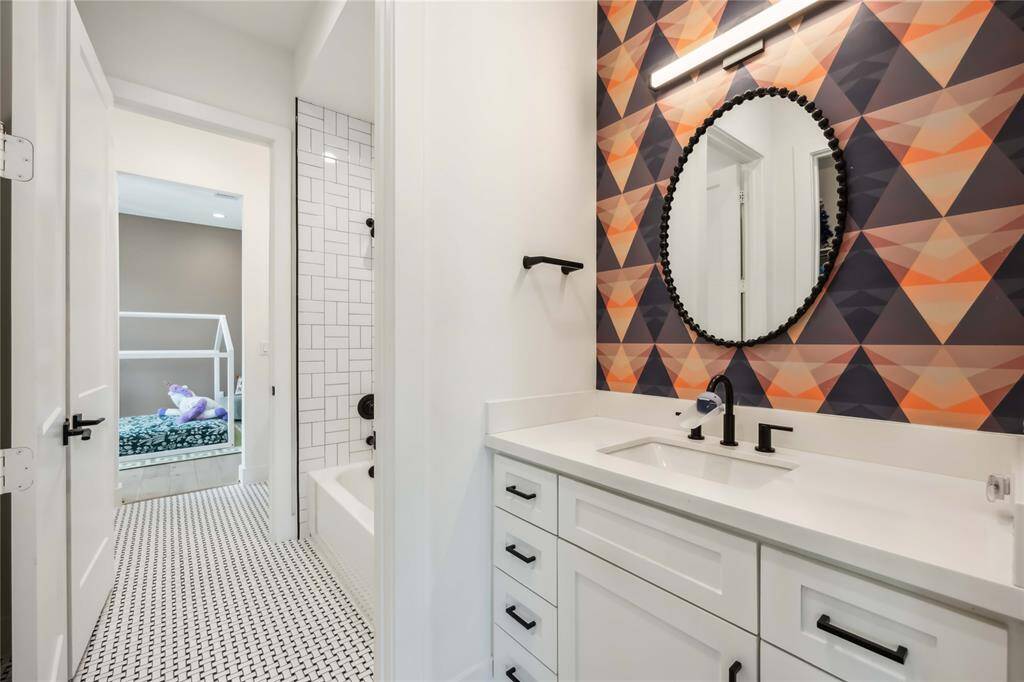 A tub/shower combo with decorative tile surround, —perfectly designed for style and convenience between two bedrooms.