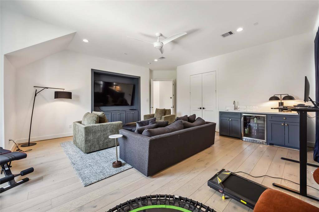 Stylish upstairs laundry room featuring a utility sink, custom pull-out ironing board, built-in cabinetry, and beautiful finishes—designed for maximum function with a touch of luxury.
