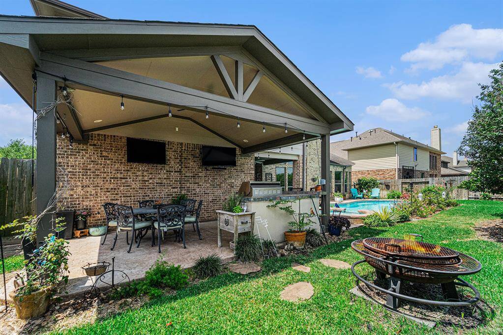 This massive covered patio with lighting, ceiling fan, 2 tv's and an outdoor kitchen offers plenty of space to watch a game, or two, while hosting a cookout. Kitchen includes a grill, counter space and built in refrigerator!