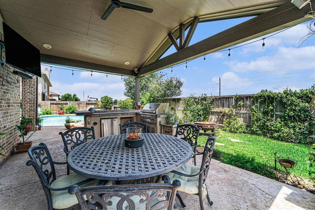 Covered patio with recessed lighting, 2 TV's, ceiling fan, bar area with grill and refrigerator, perfect for entertaining! And NO BACK NEIGHBORS