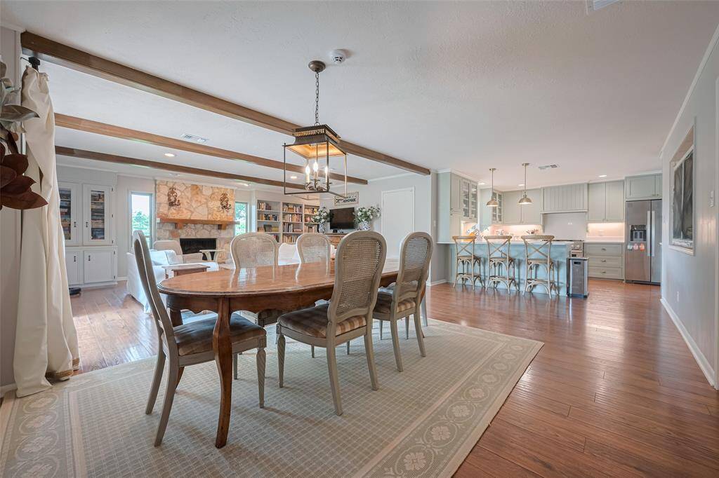 This home exudes old-world charm with its extensive built-ins, wooden beams, and limestone fire place. Kitchen breakfast area and living blend seamlessly in this open-concept great room.