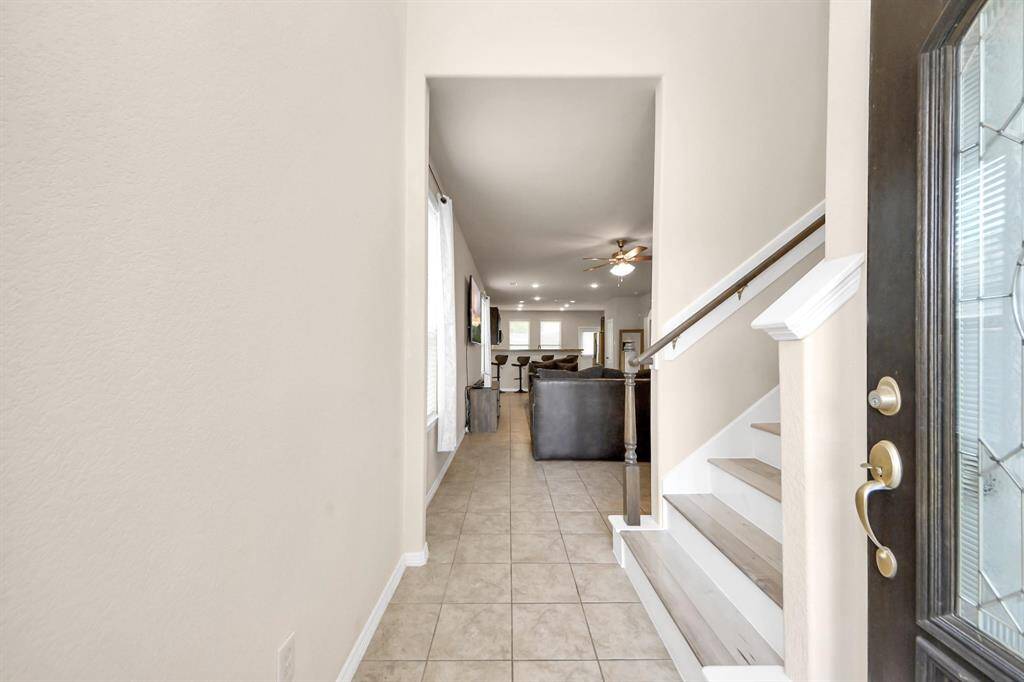 A bright entryway, sleek LVP stairs, and a seamless view into the open living room set the stage for modern, stylish living.