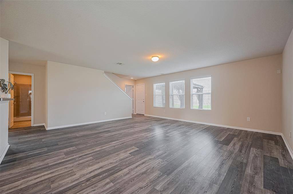 This spacious living room features modern laminate flooring, and ample natural light.