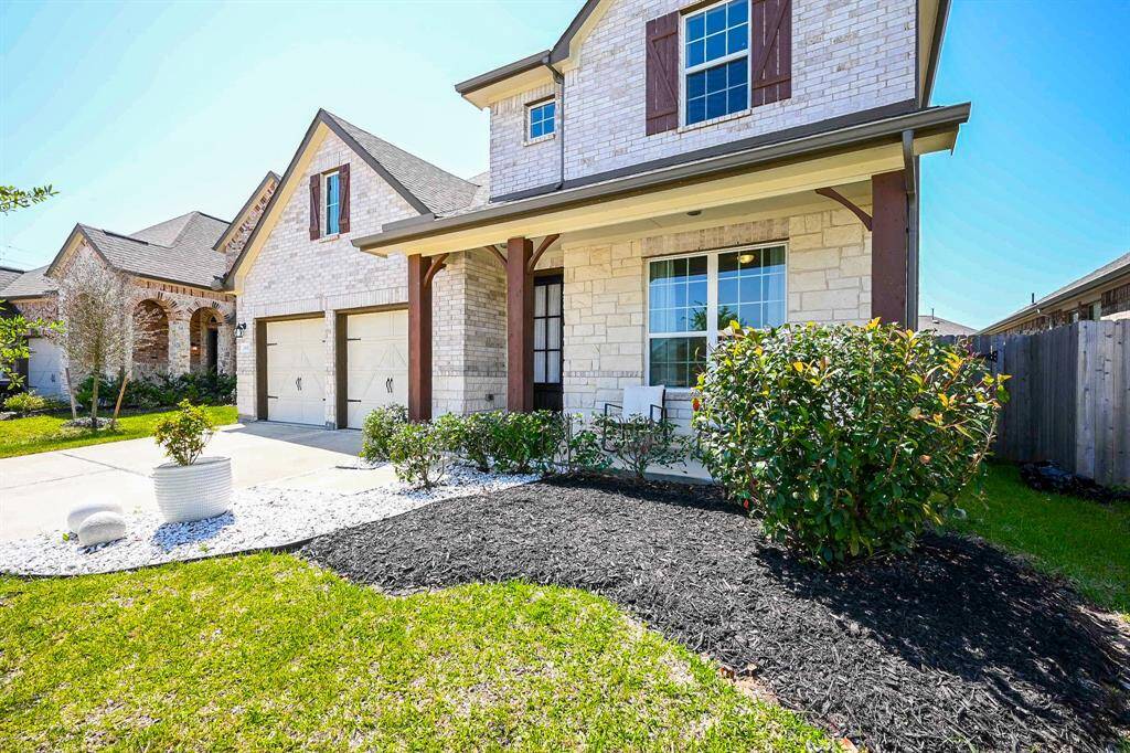 Trim landscaping meets the edge of the pristine driveway, in this front view.