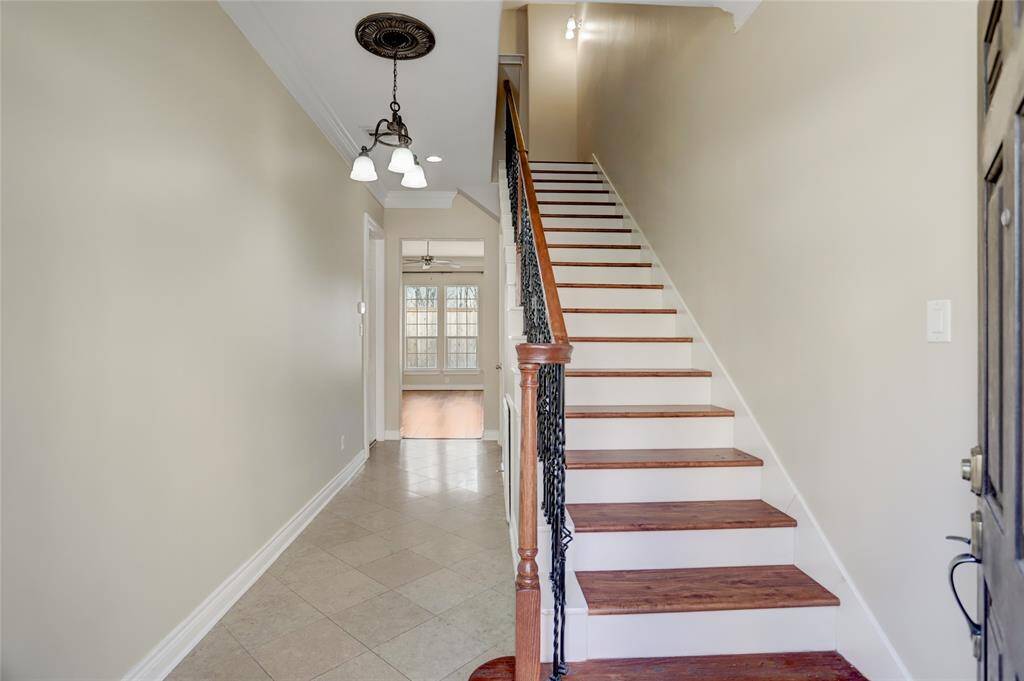 As you step inside, you're welcomed by a long foyer that guides you toward the spacious living room. To the right, a gracefully designed staircase leads to the second and third floors, where the bedrooms offer privacy and comfort.