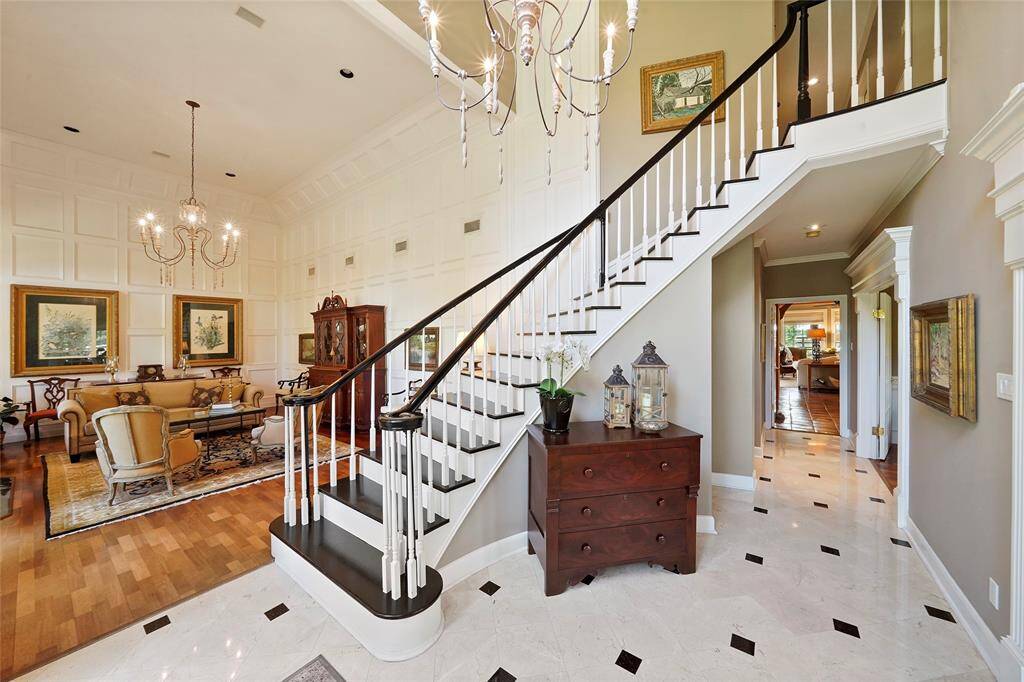 Elegant curved staircase complemented by a formal sitting area, featuring picture frame molding that adds a refined texture and enhances the room’s character.
