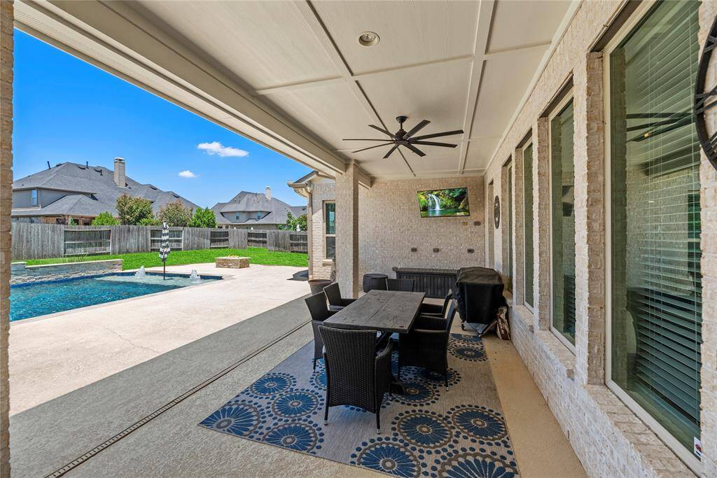 Covered patio with a ceiling fan and views of the pool, ideal for entertaining and relaxation.