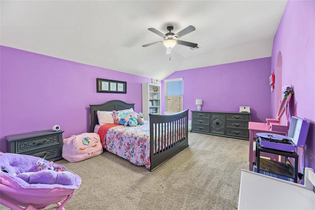 Fifth bedroom featuring a ceiling fan, a window, and carpet flooring.