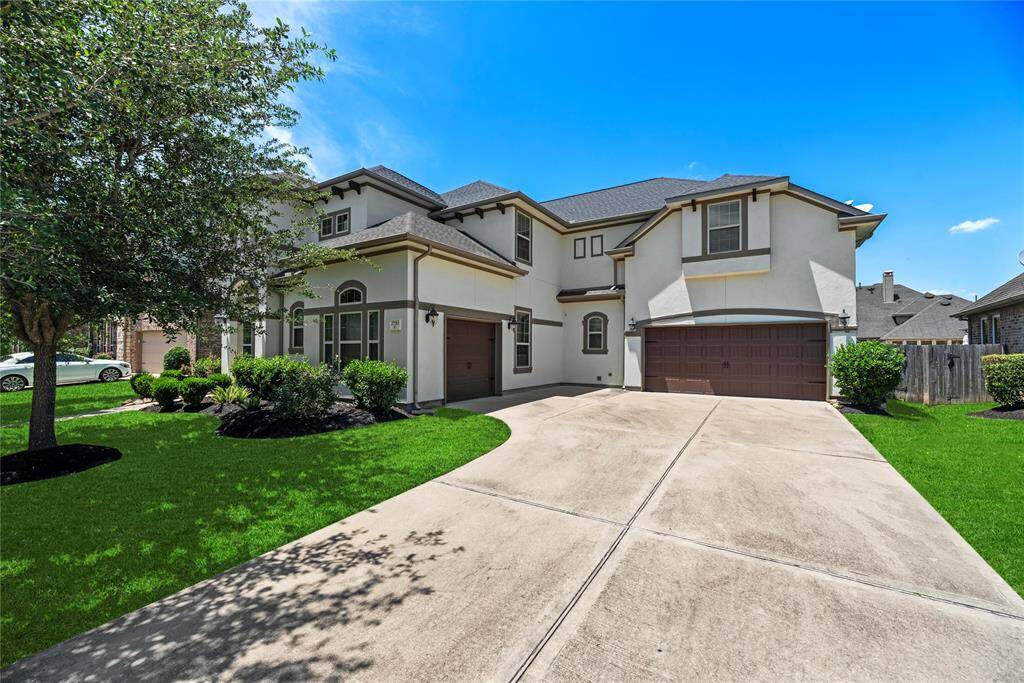 Front of the home showcasing the driveway leading to a two-car garage.