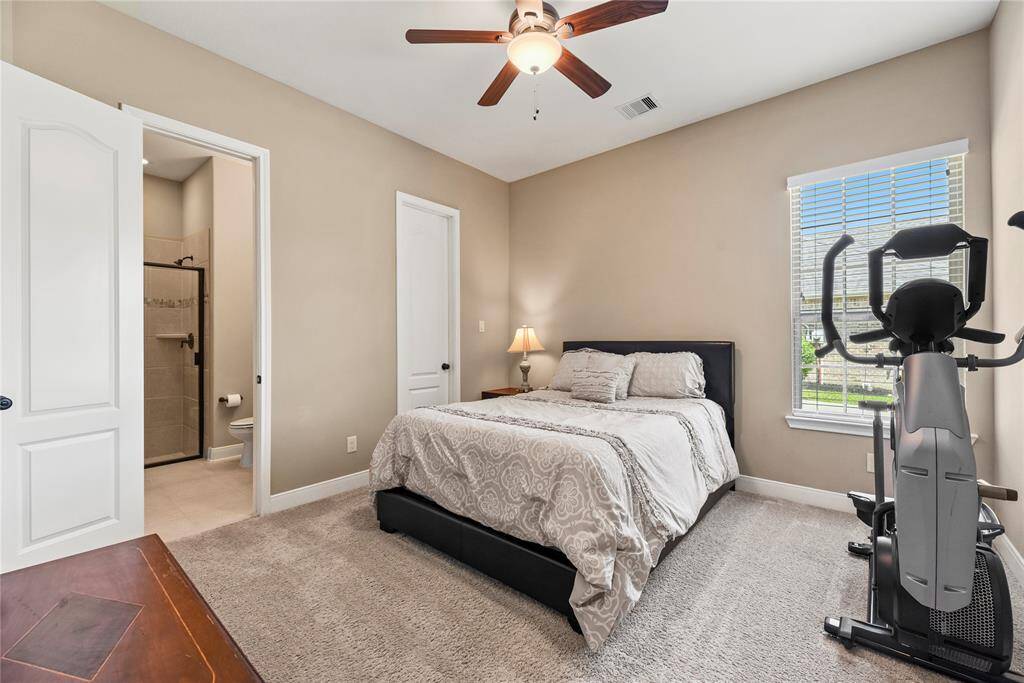 First-floor bedroom measuring 12.1 x 12.5, featuring a ceiling fan and large windows with a view of the front yard.