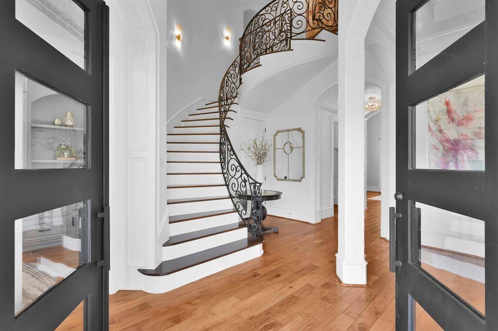 Step through elegant wrought iron doors and be greeted by a stunning spiral staircase and rich wood flooring.