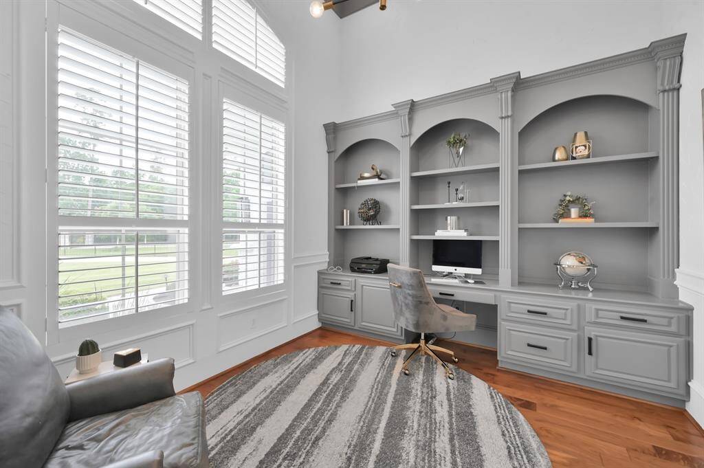 Discover the ideal home office in a private study with glass doors and built-in cabinetry.
